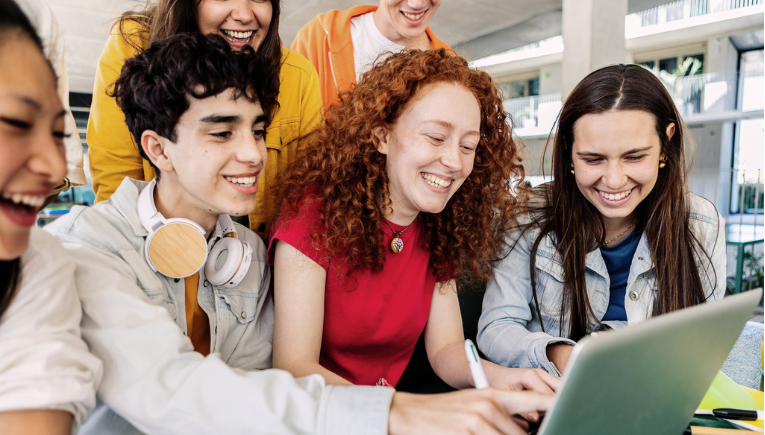 Happy students in higher education working with laptops from Signpost