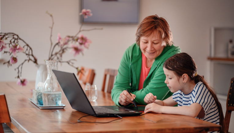 Parent helps daughter with homework on a Signpost laptop with Academic Software